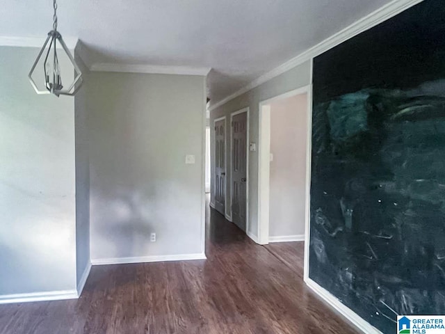 empty room featuring ornamental molding and dark hardwood / wood-style flooring