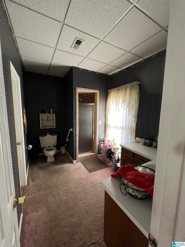 interior space featuring a paneled ceiling and carpet flooring