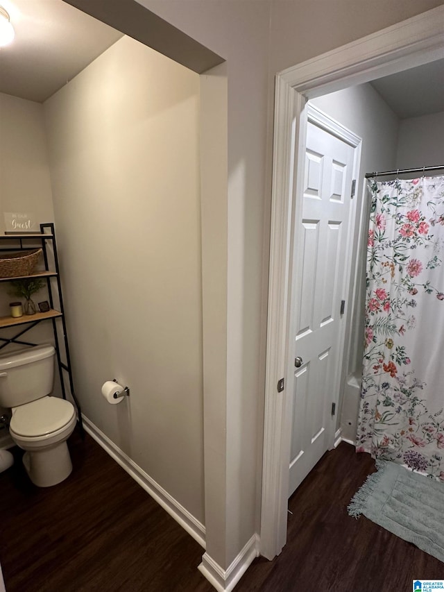 bathroom with shower / bathtub combination with curtain, toilet, and wood-type flooring