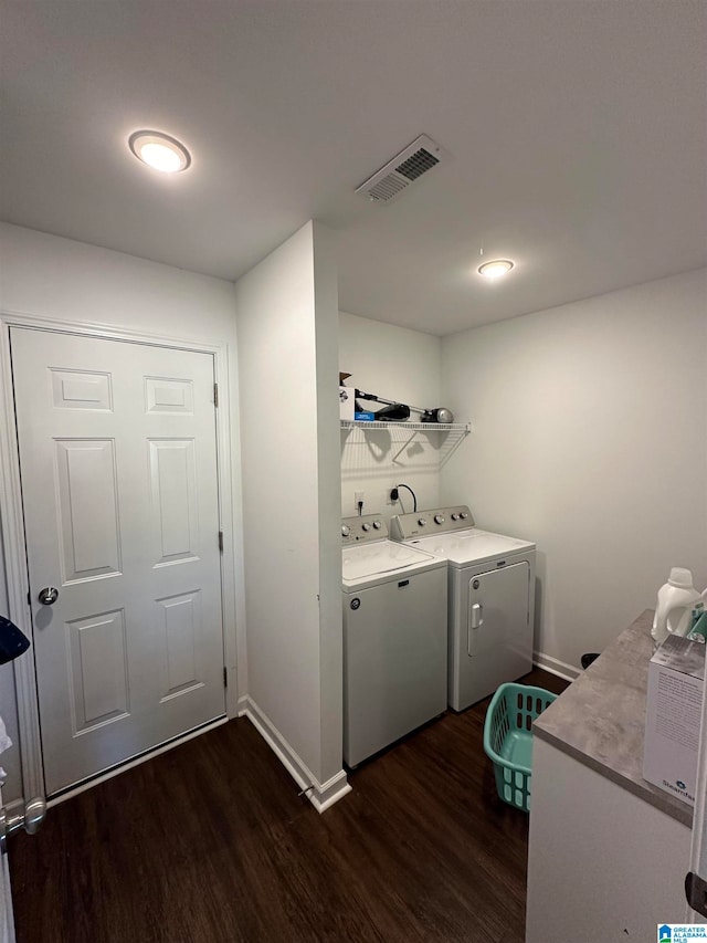 laundry area featuring washer and dryer and dark hardwood / wood-style floors