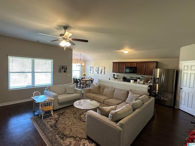 living room featuring vaulted ceiling, ceiling fan with notable chandelier, and dark hardwood / wood-style floors