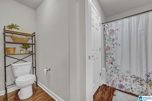 bathroom with hardwood / wood-style floors, toilet, and walk in shower