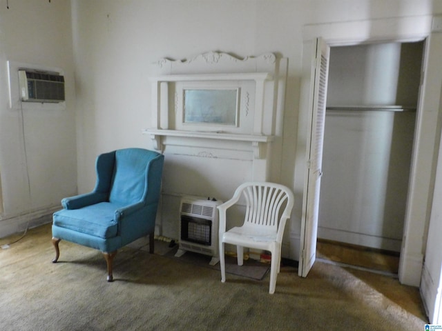 sitting room with carpet, heating unit, and a wall mounted air conditioner