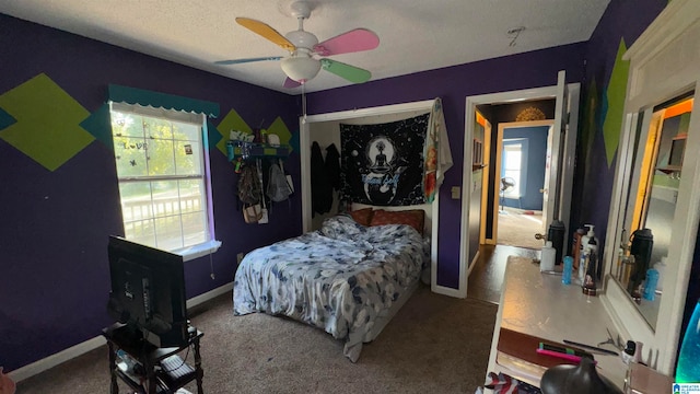 carpeted bedroom with a textured ceiling and ceiling fan