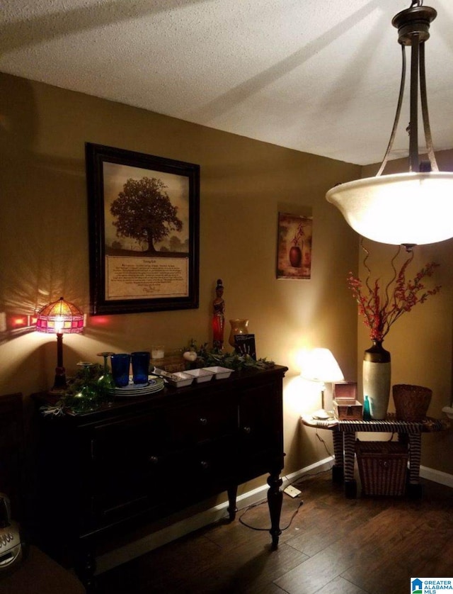 interior space with a textured ceiling and dark hardwood / wood-style flooring