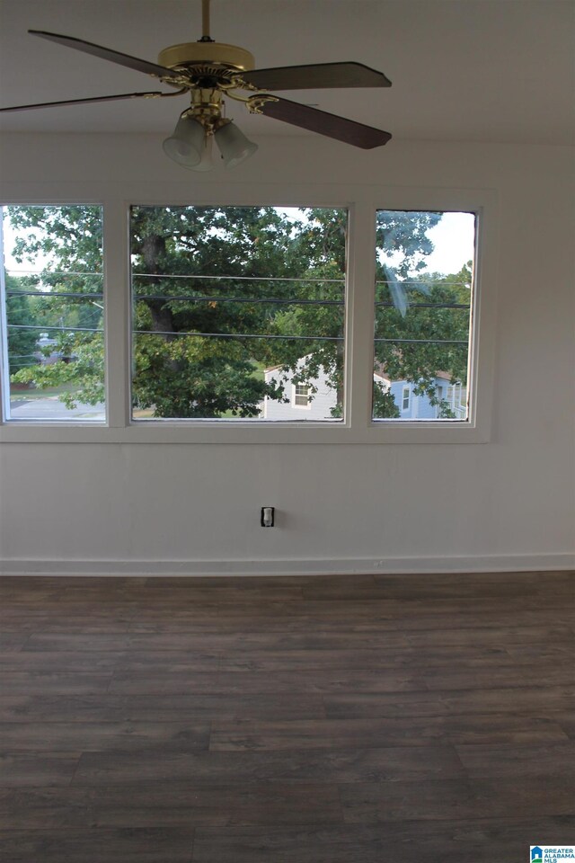 empty room featuring dark hardwood / wood-style flooring and ceiling fan