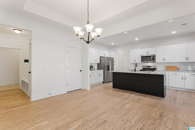 kitchen with white cabinetry, light hardwood / wood-style floors, appliances with stainless steel finishes, and a center island with sink