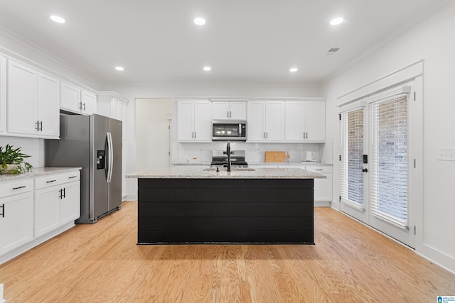 kitchen featuring an island with sink, stainless steel appliances, white cabinets, and light wood-type flooring