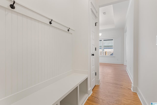 mudroom with light hardwood / wood-style flooring and crown molding