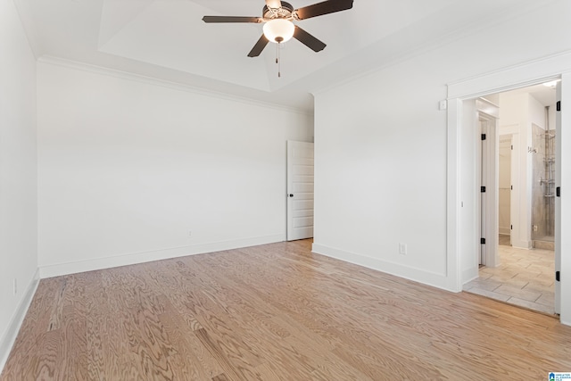 empty room with ceiling fan, crown molding, and light hardwood / wood-style floors