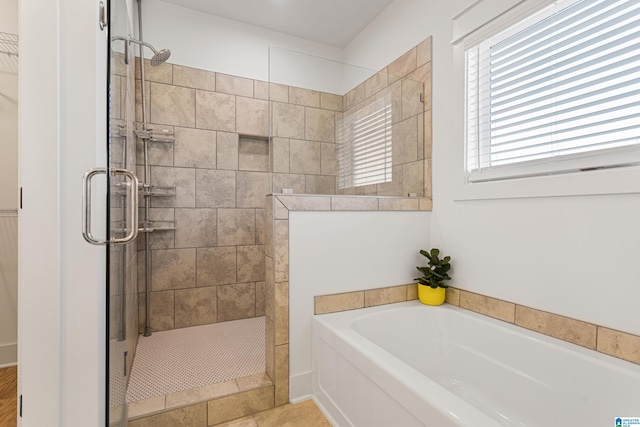 bathroom featuring independent shower and bath