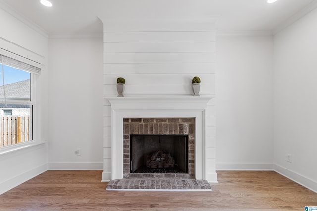 room details with a brick fireplace, wood-type flooring, and crown molding