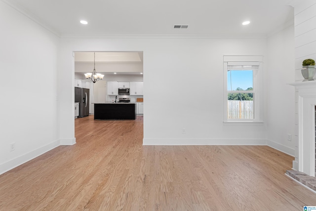 unfurnished living room with an inviting chandelier, light hardwood / wood-style floors, and ornamental molding