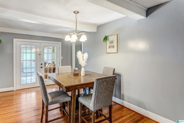 dining room featuring french doors, an inviting chandelier, beamed ceiling, and hardwood / wood-style floors