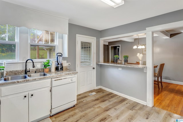 kitchen featuring white cabinets, sink, dishwasher, a notable chandelier, and light hardwood / wood-style floors