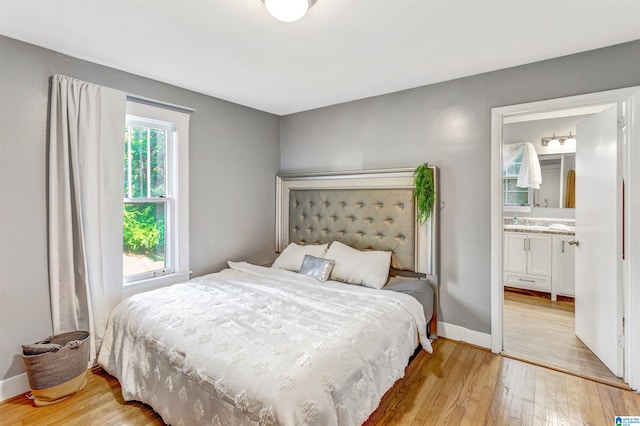 bedroom featuring light hardwood / wood-style flooring and ensuite bath