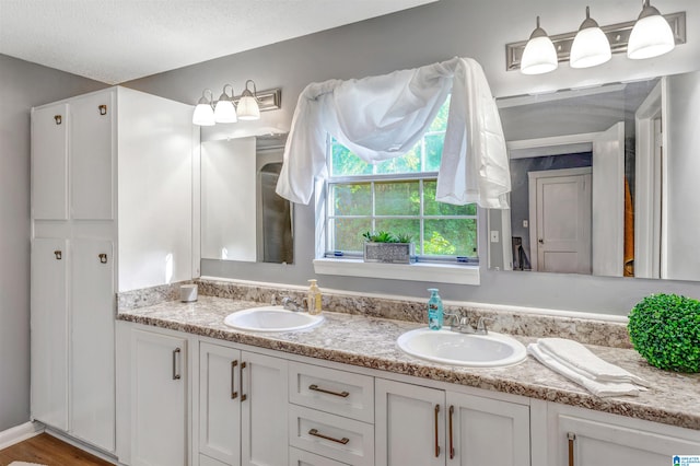 bathroom featuring hardwood / wood-style floors, a textured ceiling, and vanity