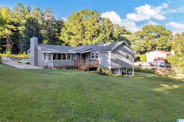 back of property with a wooden deck and a lawn