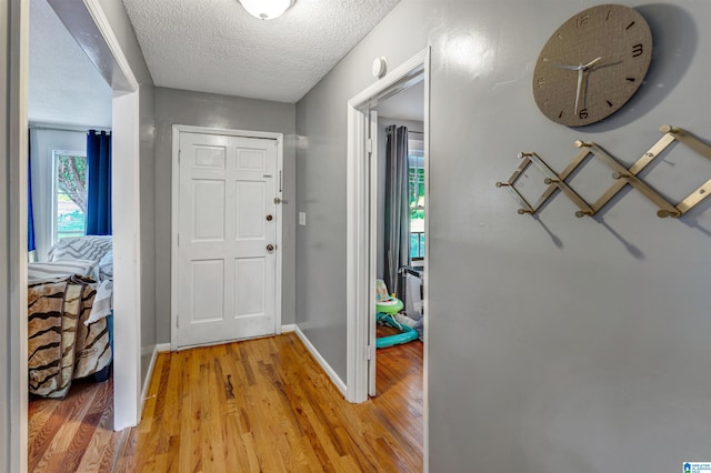 entryway featuring a textured ceiling and light hardwood / wood-style flooring