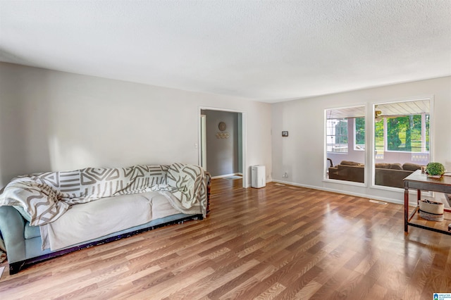 bedroom with a textured ceiling and hardwood / wood-style flooring