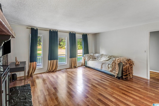 living room with a textured ceiling and hardwood / wood-style floors