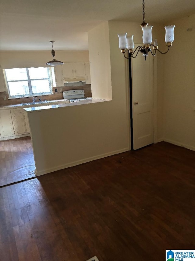 interior space featuring white cabinetry, dark hardwood / wood-style flooring, white range, decorative light fixtures, and a notable chandelier