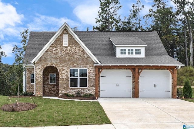 view of front of property featuring a front yard and a garage