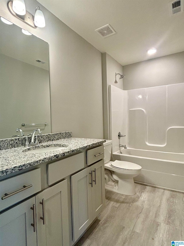 full bathroom with  shower combination, vanity, toilet, and hardwood / wood-style flooring