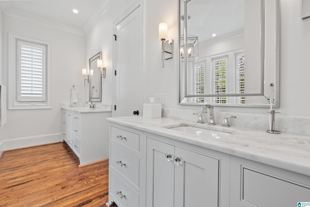 bathroom with wood-type flooring, vanity, and crown molding