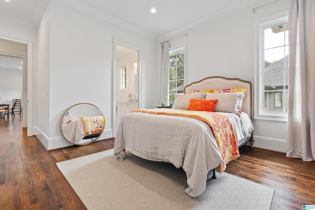 bedroom featuring ensuite bath, multiple windows, dark wood-type flooring, and crown molding