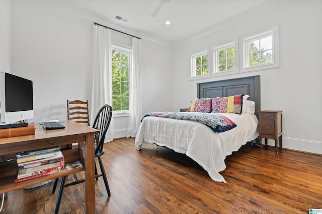 bedroom with ceiling fan, ornamental molding, and dark wood-type flooring