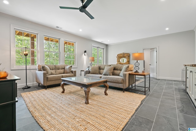 living room with crown molding, ceiling fan, and dark tile patterned floors