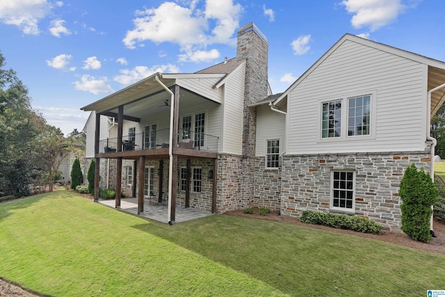 back of house featuring a balcony, a yard, and a patio