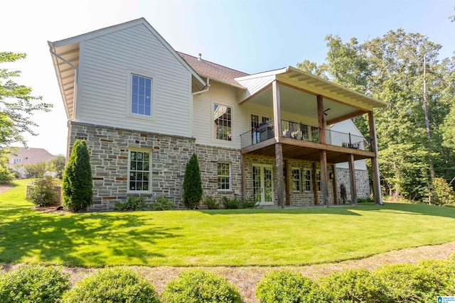 back of house featuring a balcony and a lawn