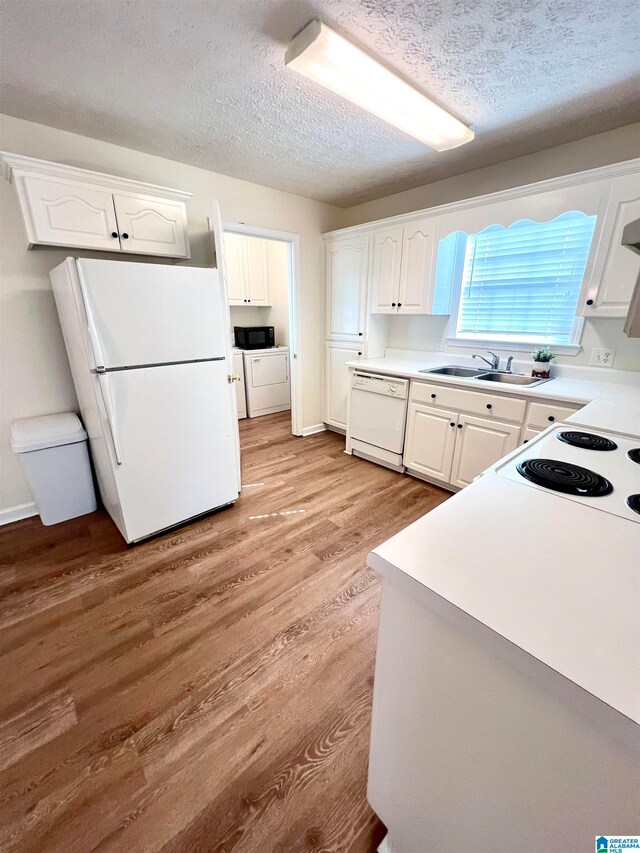 kitchen with a textured ceiling, light hardwood / wood-style floors, sink, white cabinetry, and white appliances