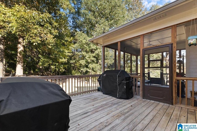 deck featuring a sunroom and a grill