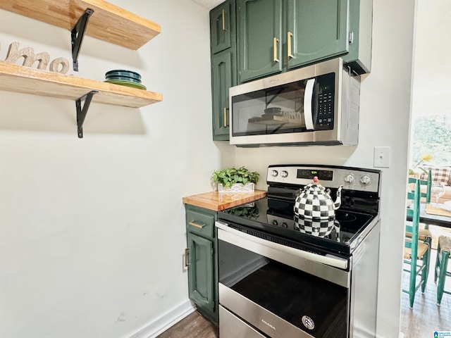 kitchen featuring green cabinetry, stainless steel appliances, dark hardwood / wood-style floors, and wood counters