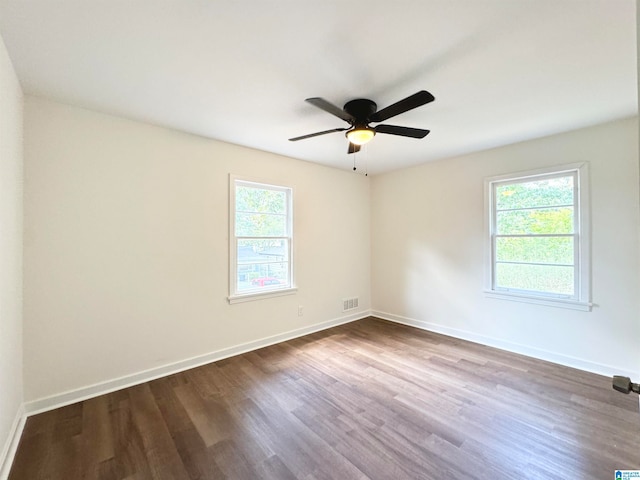 unfurnished room featuring a healthy amount of sunlight, hardwood / wood-style floors, and ceiling fan