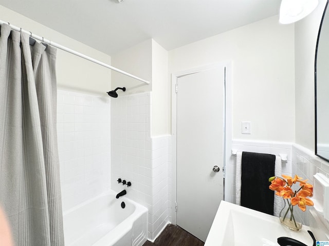 bathroom with wood-type flooring, shower / tub combo with curtain, vanity, and tile walls