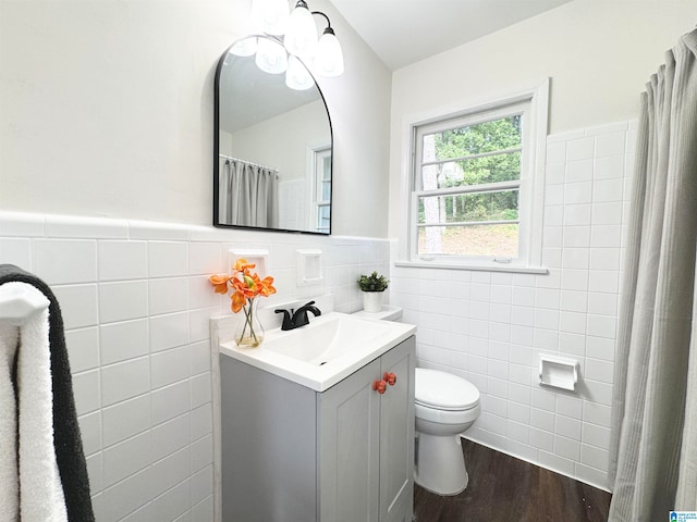 bathroom featuring vanity, tile walls, hardwood / wood-style floors, and toilet