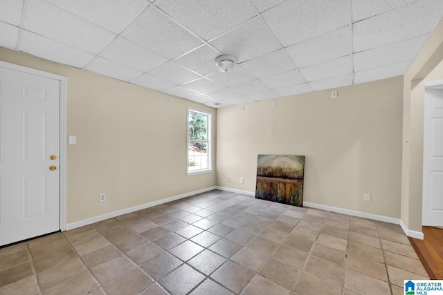 unfurnished living room featuring light tile patterned flooring and a drop ceiling