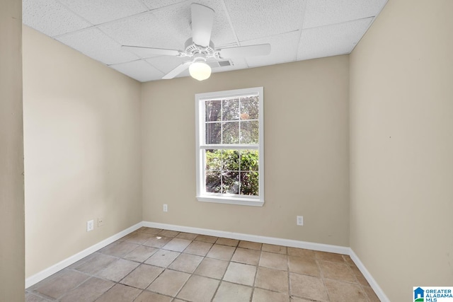 unfurnished room with a paneled ceiling, light tile patterned floors, and ceiling fan