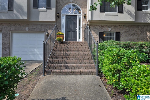 entrance to property featuring central AC unit and a garage