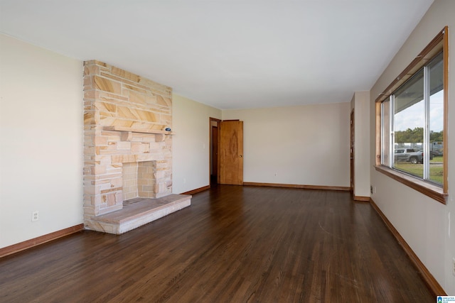 unfurnished living room featuring a fireplace and dark hardwood / wood-style floors