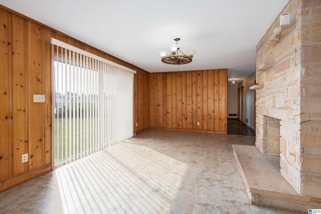 interior space with a fireplace, wood walls, and a chandelier