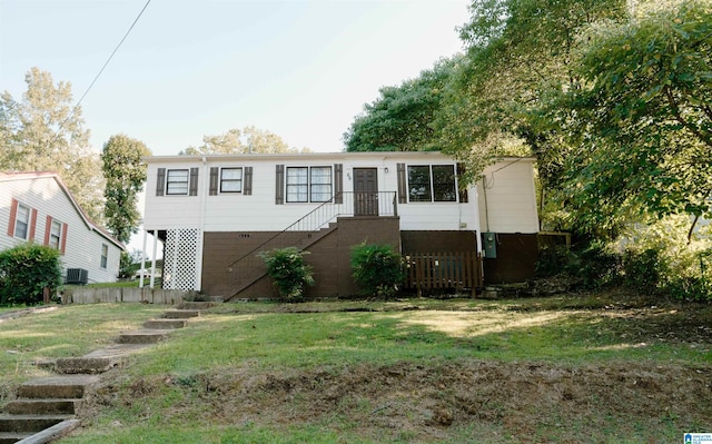 view of front of house with a front yard and central air condition unit