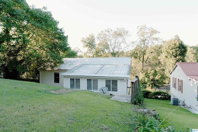 view of front facade featuring a front yard and central air condition unit