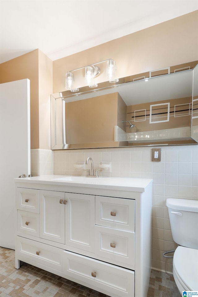 bathroom featuring tile walls, vanity, and toilet