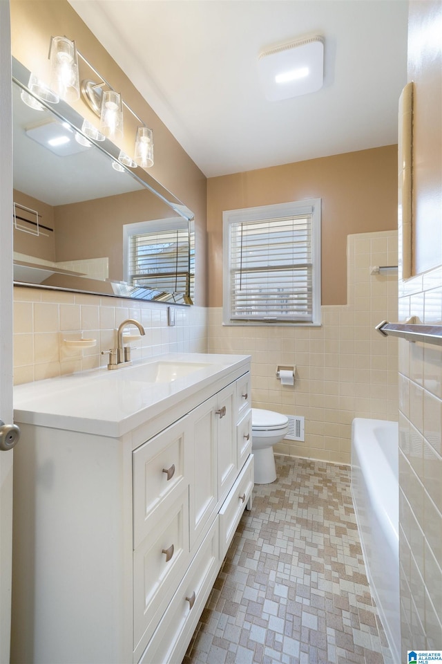 full bathroom featuring vanity, tile walls, bathtub / shower combination, and toilet