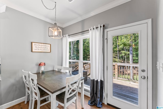 dining space with wood-type flooring and crown molding